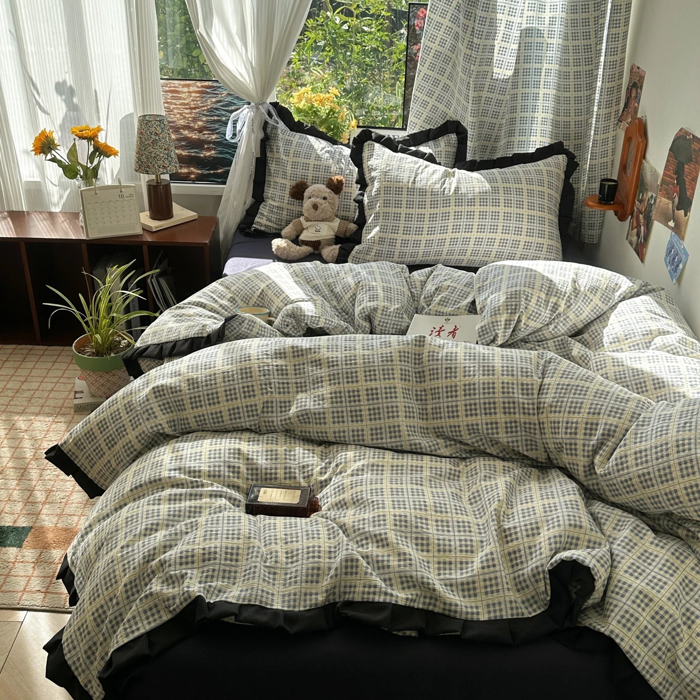 Bed with plaid comforter in a room with curtains and decor