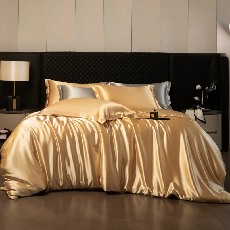 Gold satin bedding set on a bed with a dark headboard in a bedroom setting.