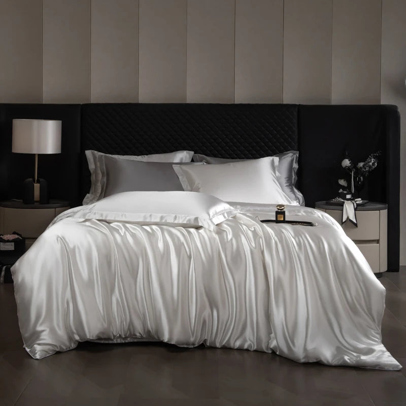 Bed with white satin sheets and pillows in a bedroom setting.